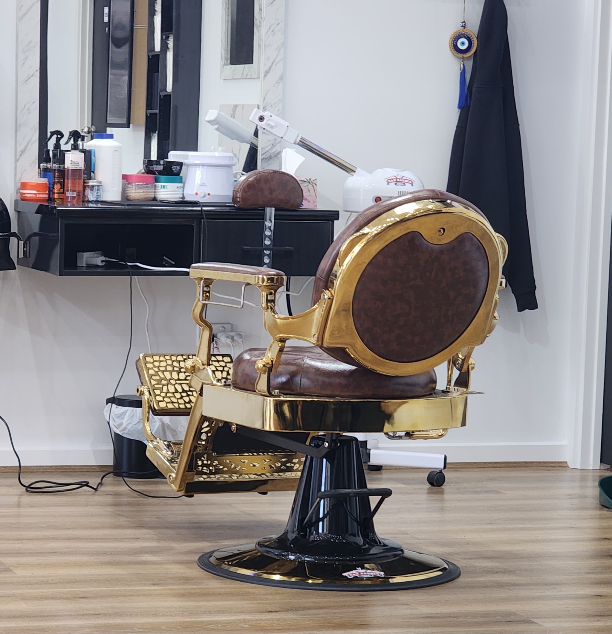 An ornate gold and brown leather vintage barber chair inside the shop