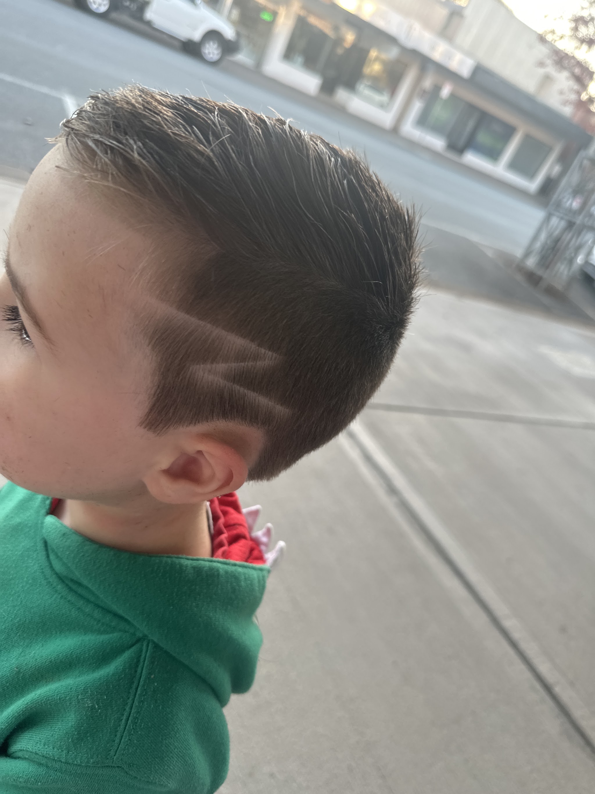 A child's skin fade with a shaved line design
